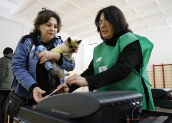 Γεωργιανή ψηφίζει μαζί με τον σκύλο της σε εκλογικό κέντρο στην Τιφλίδα (φωτ.: EPA/David Mdzinarishvili)