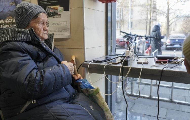 Ηλικιωμένη Ουκρανία φορτίζει το κινητό της σε σουπερμάρκετ το οποίο διαθέτει γεννήτρια στο Μικολάιβ, το οποίο δεν έχει ρεύμα τις τελευταίες 35 ώρες μετά από εκτεταμένες ρωσικές επιθέσεις (φωτ.: EPA/Anna Hakman)