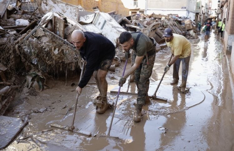 Πολίτες καθαρίζουν δρόμο στην Παϊπόρτα, στην επαρχία της Βαλένθια μετά τις καταστροφικές πλημμύρες (φωτ.: EPA/Biel Alino)