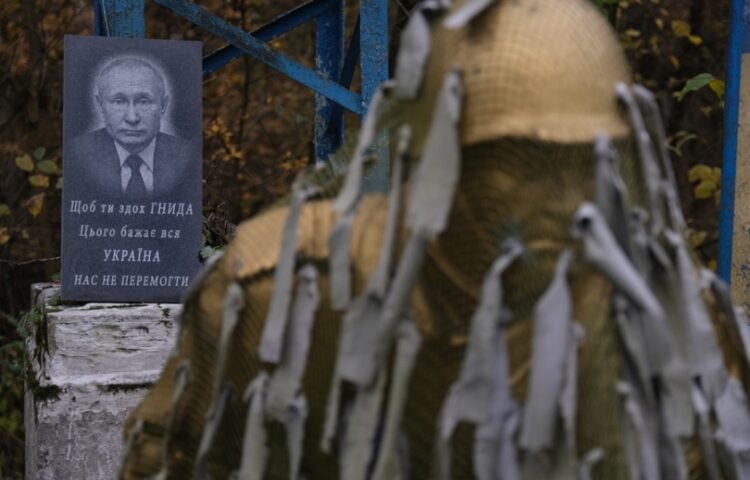 Ταφόπλακα με τη φωτογραφία του Βλαντίμιρ Πούτιν πίσω από μνημείο για τους ναρκαλιευτές, σε στρατιωτική βάση στην Ουκρανία. Η συγκεκριμένη υπηρεσία έχει καταστρέψει πάνω από 200.000 νάρκες στα ουκρανικά εδάφη από την αρχή της ρωσικής εισβολής (φωτ.: EPA/Maria Senovilla)