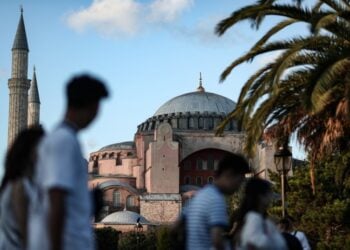 Τουρίστες προσπερνούν την Αγια-Σοφιά στην Κωνσταντινούπολη, τον περασμένο Ιούλιο (φωτ.: EPA/Erdem Sahin)