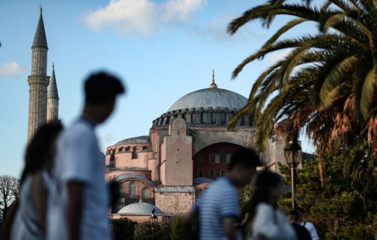 Τουρίστες προσπερνούν την Αγια-Σοφιά στην Κωνσταντινούπολη, τον περασμένο Ιούλιο (φωτ.: EPA/Erdem Sahin)