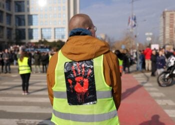 Διαδηλωτής φορά γιλέκο που απεικονίζει ένα ματωμένο χέρι, στη διάρκεια διαμαρτυρίας και αποκλεισμού της «Γέφυρας της Ελευθερίας» (Most Slobode) στο Νόβι Σαντ (φωτ.: EPA/ANDREJ CUKIC)