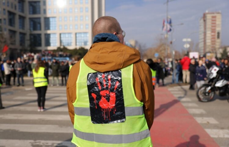 Διαδηλωτής φορά γιλέκο που απεικονίζει ένα ματωμένο χέρι, στη διάρκεια διαμαρτυρίας και αποκλεισμού της «Γέφυρας της Ελευθερίας» (Most Slobode) στο Νόβι Σαντ (φωτ.: EPA/ANDREJ CUKIC)